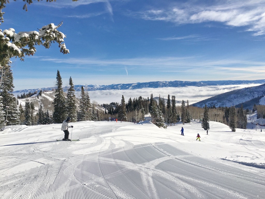 Groomed runs above the clouds on a bluebird day at Canyons Village